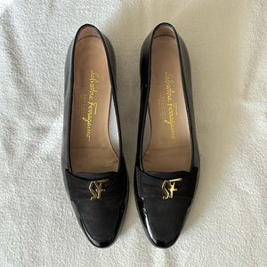 Salvatore Ferragamo black low heel loafer with gold vintage logo ornament.